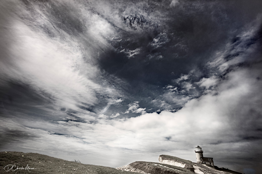 Bell Tout Lighthouse 
 The changing and dynamic coastline with the Bell Tout hotel (formerly lighthouse) looking out over the English Channel from the South Downs Way. 
 Keywords: Sussex landscape, Sussex coast, Bell Tout, Bell Tout lighthouse, lighthouse, stormy sky, Beachy Head, South Downs,